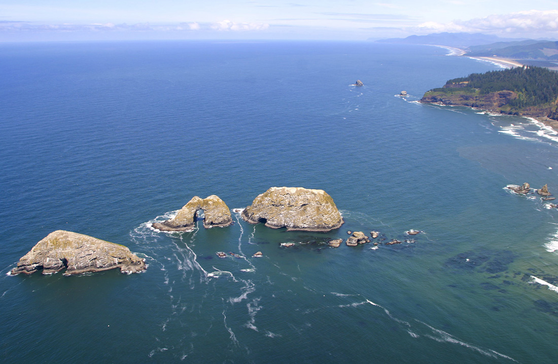 Aerial View of Three Arch Rocks National Wildlife Refuge with Cape Meares in the background.