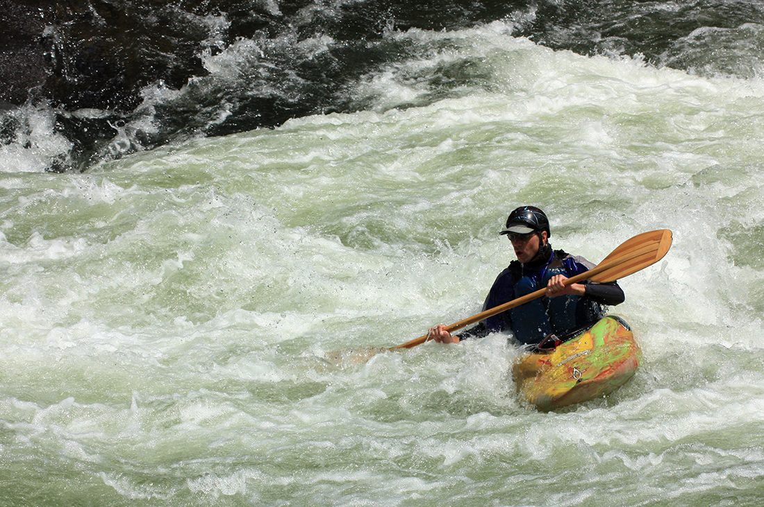 A kayaker banks against whitewater rapids in the fast-moving Youghiogheny River.