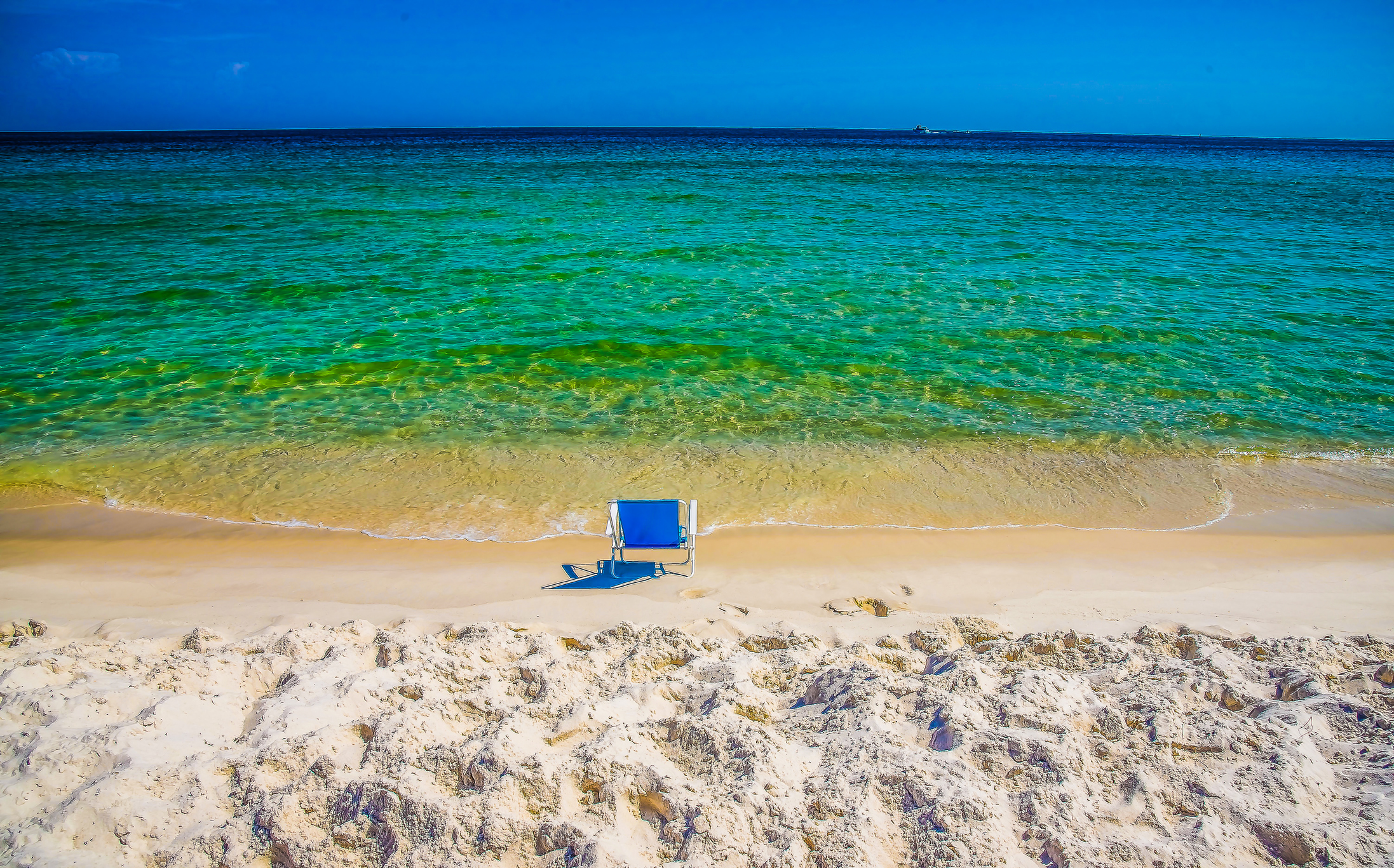 An empty blue chair on the gorgeous beach of Orange Beach, Alabama