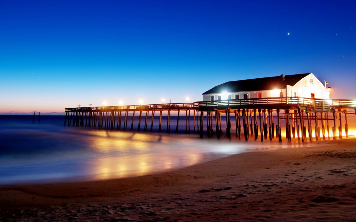 Sunrise with bright blue sky at pier and beach