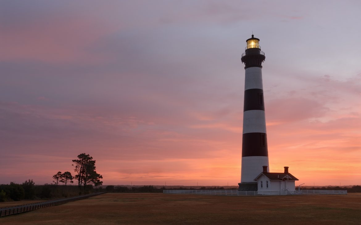 Colorful sky at dawn of lighthouse, with colors of pink and orange.