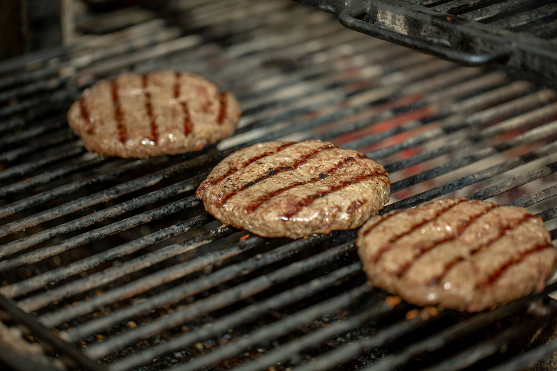 Sausage patties sizzle on the grill.