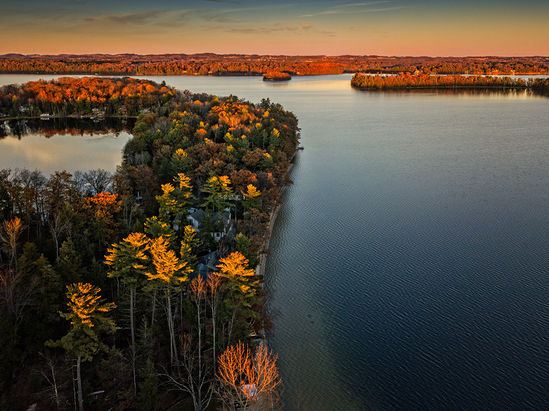 Islands dappled golden foliage sit on calm waters in Michigan.