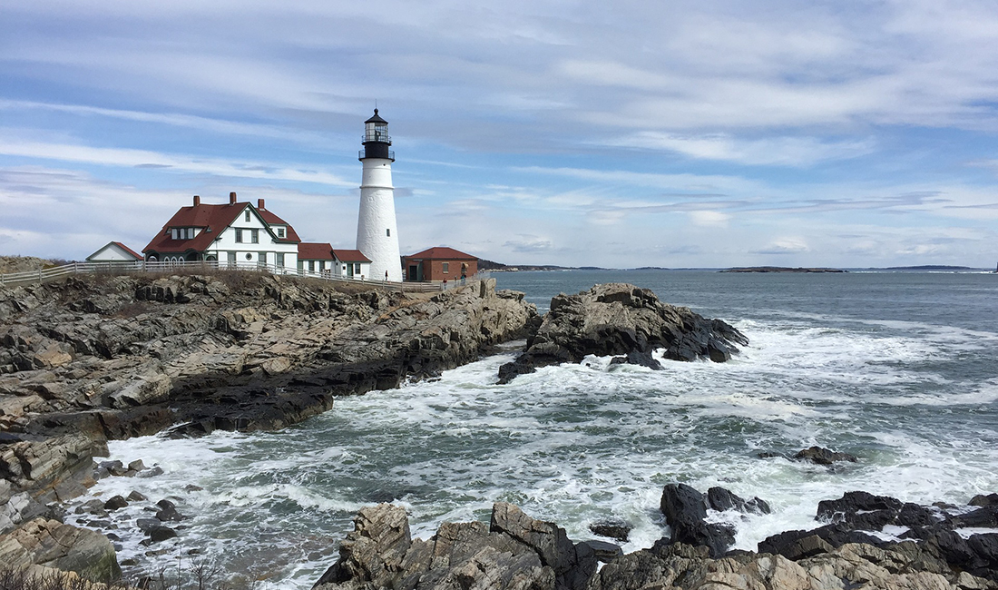 A lighthouse stands guard on a rocky peninsula. Photo: Getty Images