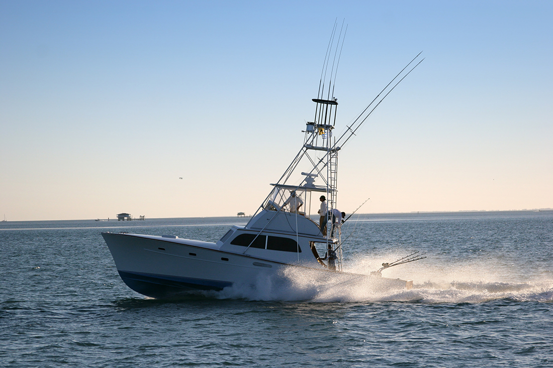 A charter fishing craft motors out to sea.