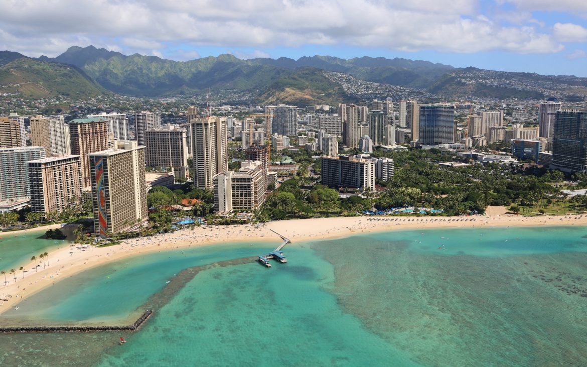 Ariel view of turquoise ocean and tall buildings in Hawaii