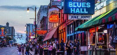 Main street of Memphis, Tennessee, at dusk showing Blues Hall and pub lit signs