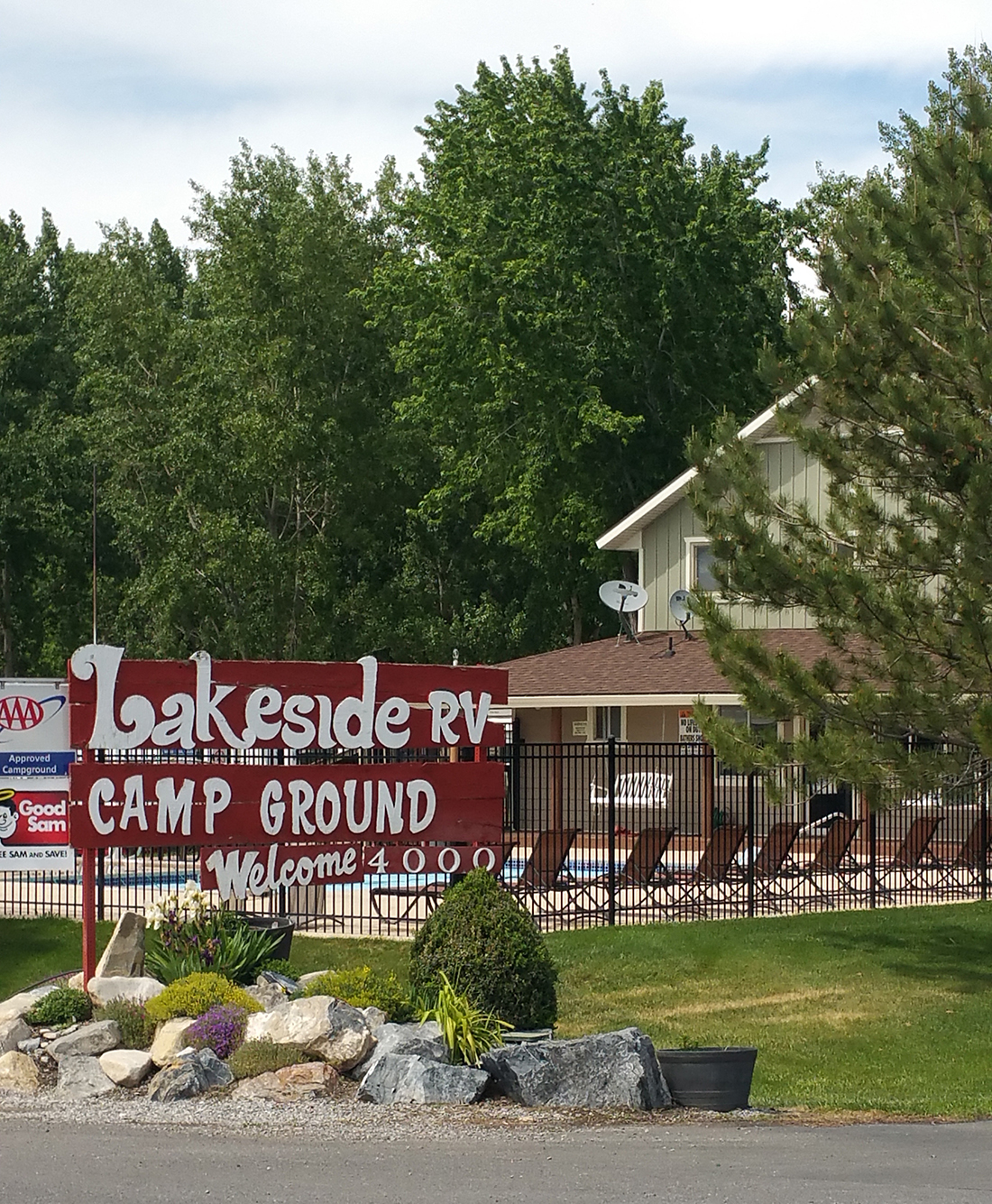 Lakeside RV Campground sign with building and pool in background.