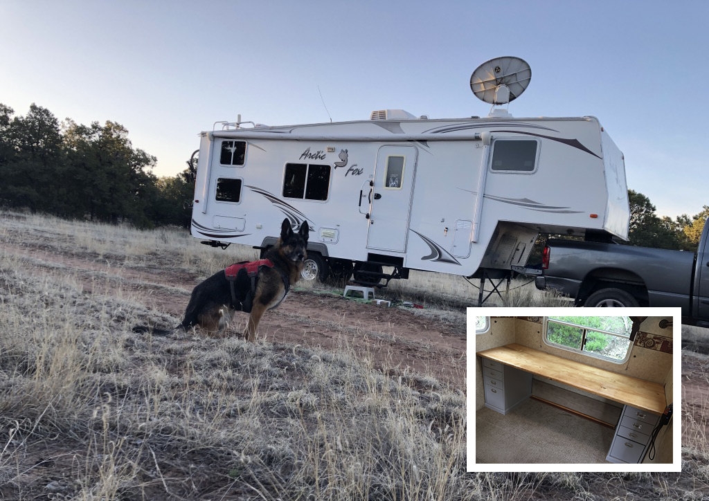 A German shepherd stands outside of a fifth-wheel with a satellite dish