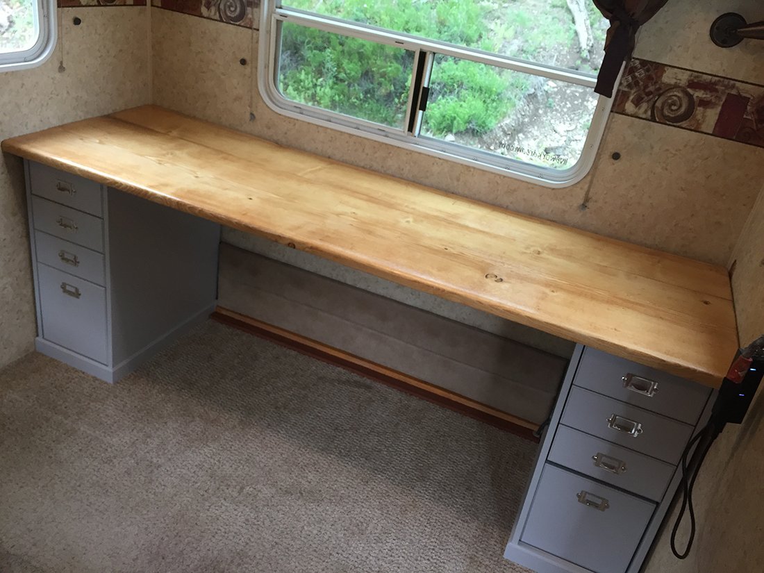 A wood topped desk occupies the with of an extended fifth-wheel slide-out.
