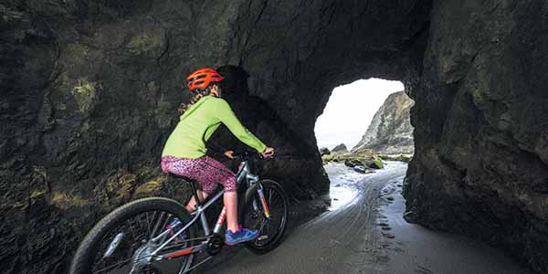 Riding through a sea cave between Bandon’s South Jetty and China Creek.