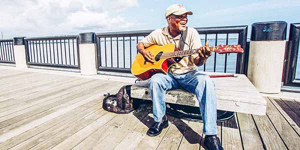 Man playing the guitar on the pier