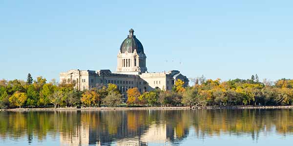The Saskatchewan Legislative Building is reflected in Wascana Lake