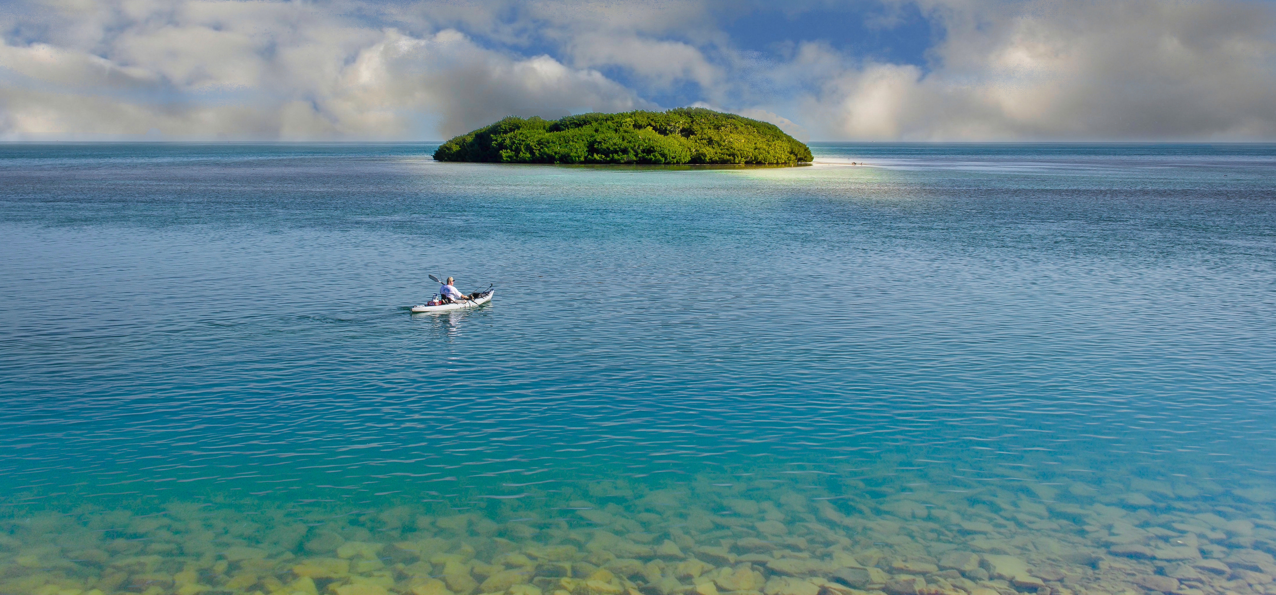 A lone kayaker paddles out to a remote island.