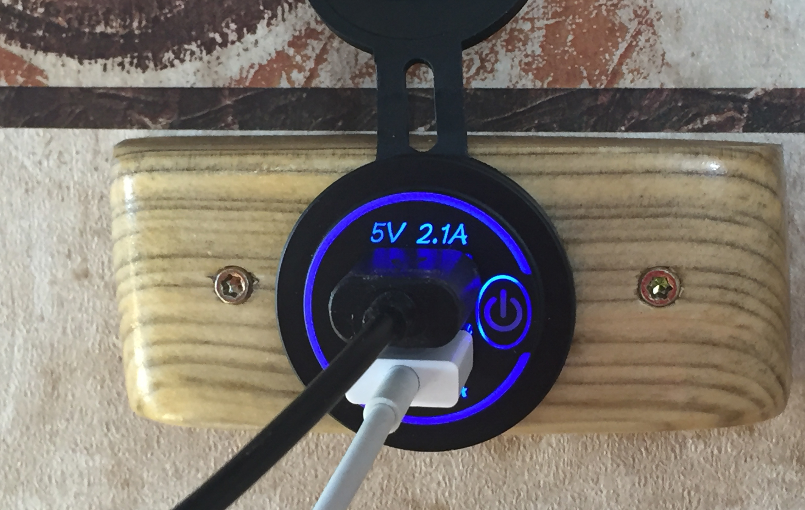 A USB port with a cobalt blue readout on an RV wall.