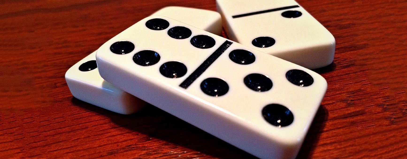 Dominoes on a teak surface.
