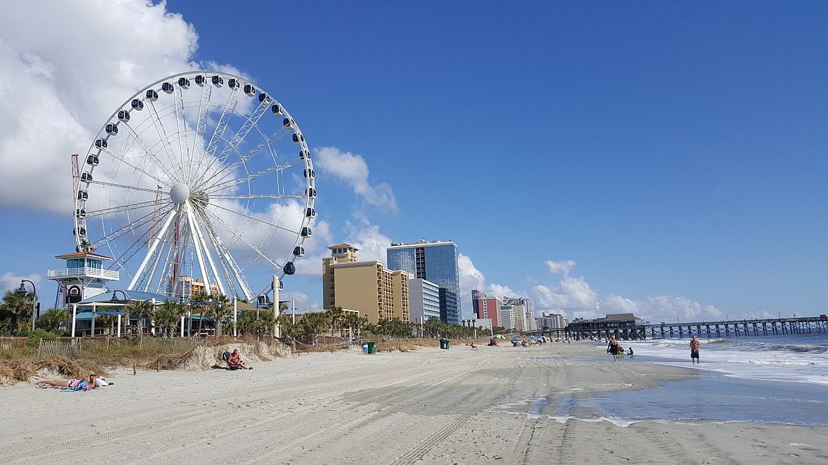 south brunswick islands north carolina — A coast with resort hotels, a life guard tower and Ferris wheel.