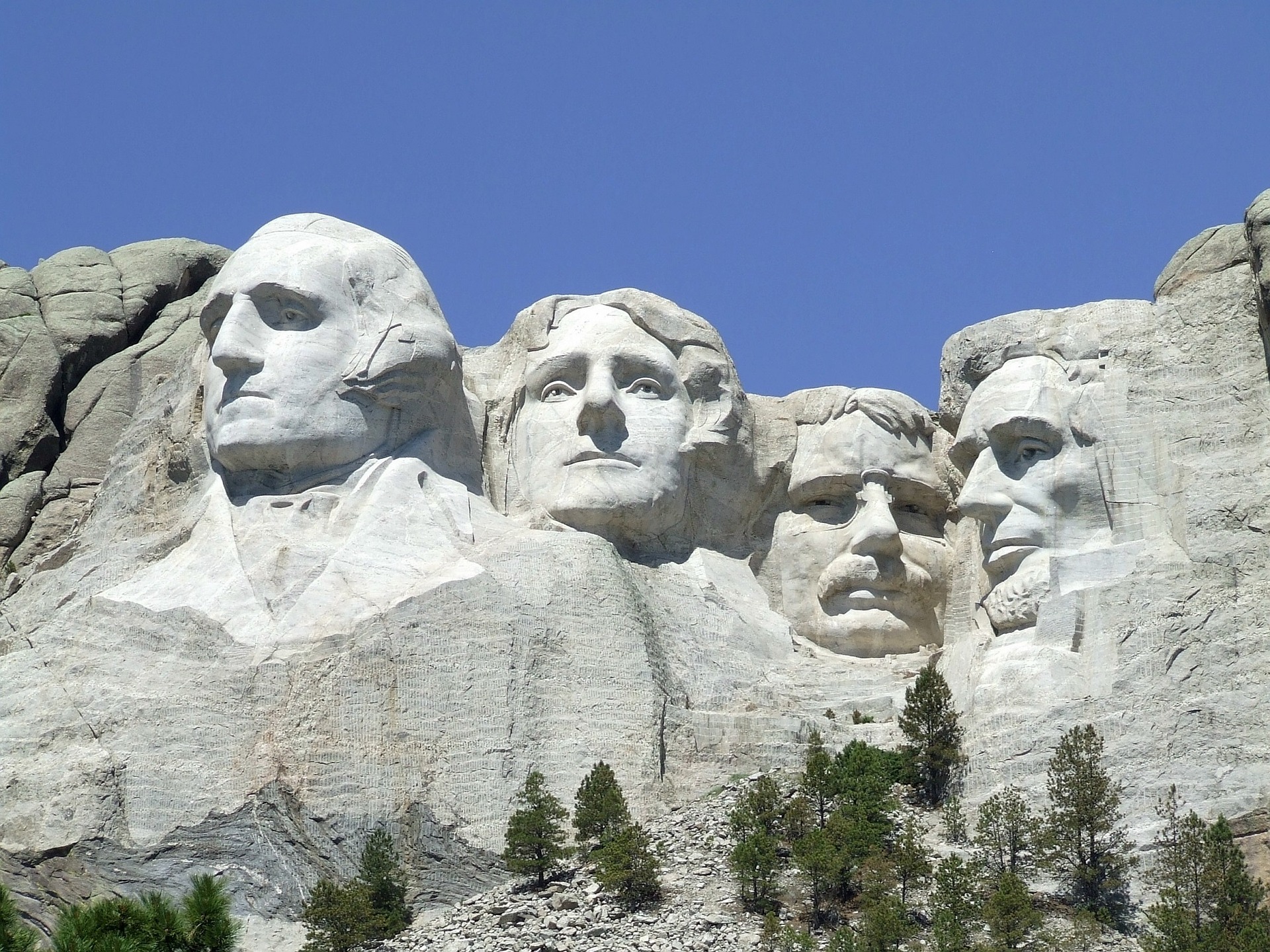 Four presidents carved into stone in a mountain.