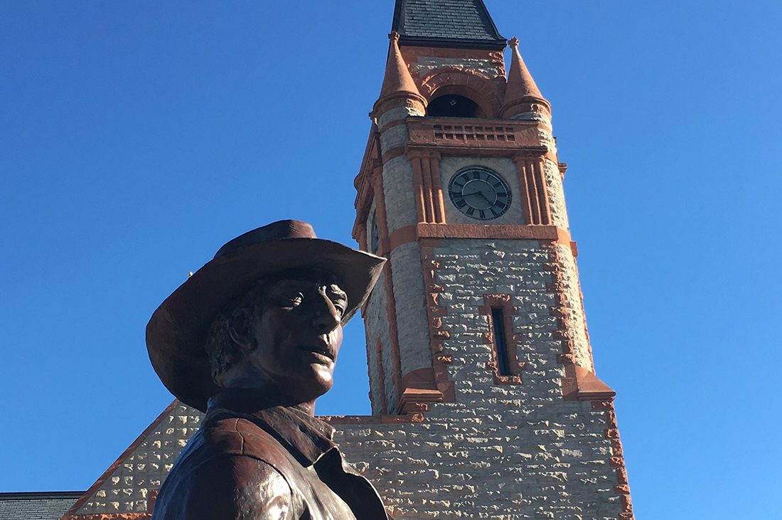 A bronze statue of a cowboy gazing into the distance.
