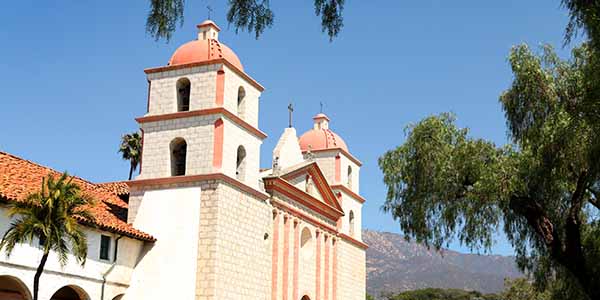 A view of the Santa Barbara Mission, with its bricks, red tiles and twin bell towers.
