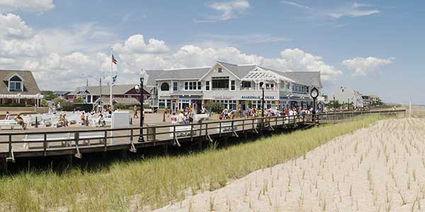 A broad pavilion overlooks the beach with white house in background.