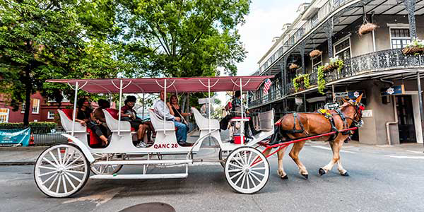 A carriage carts tourists through the streets of the French Quarter. 