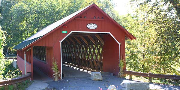 The Red Covered Bridge with large rocks in front of it