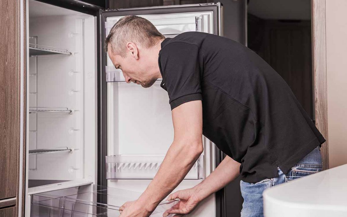 Man cleaning RV fridge