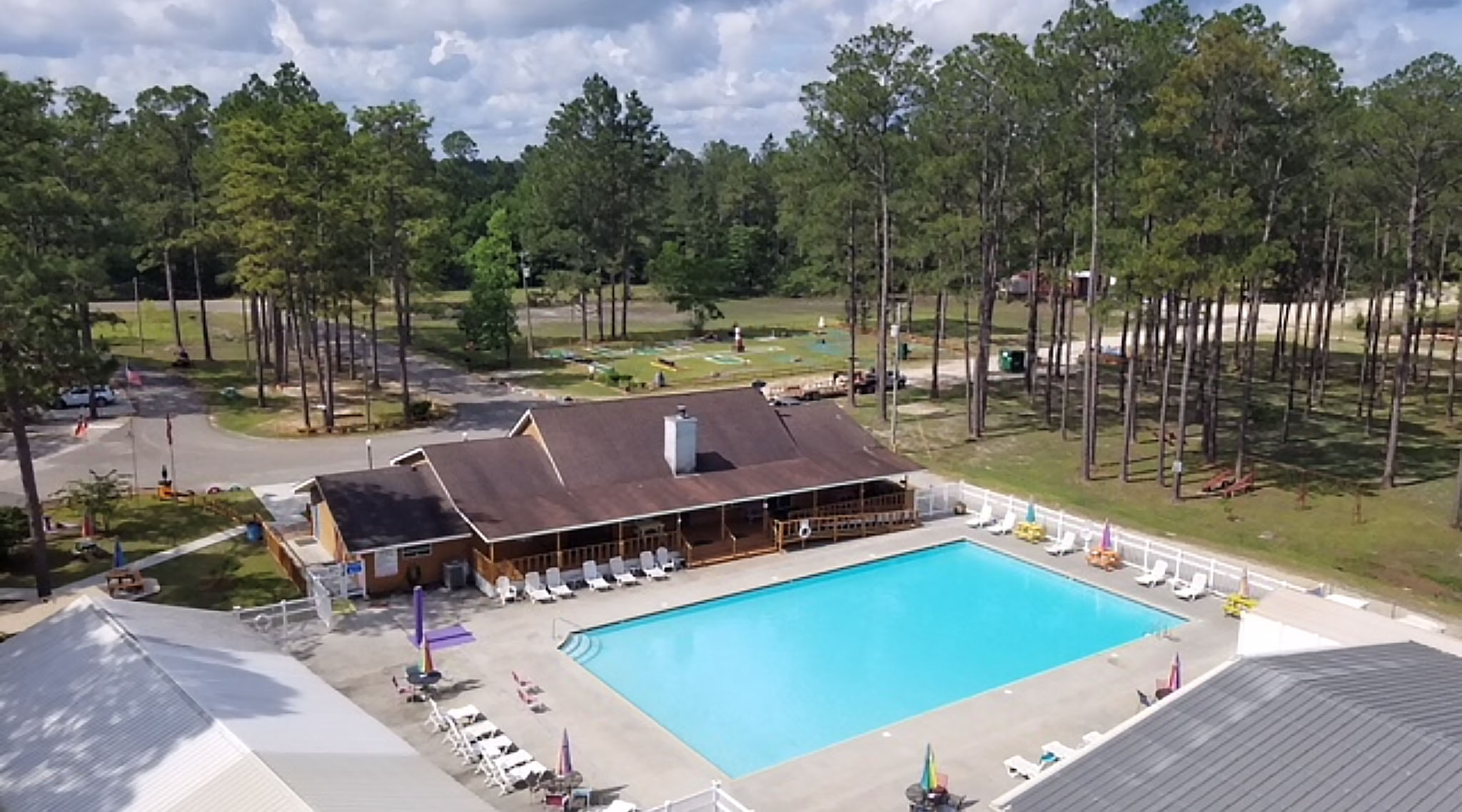 A park clubhouse overlooking a large, rectangular pool.