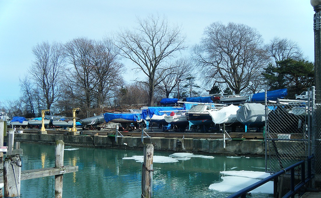 Boats parked in winter storage on the banks of a channel.