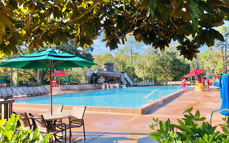 Rectangular pool with slide in background.