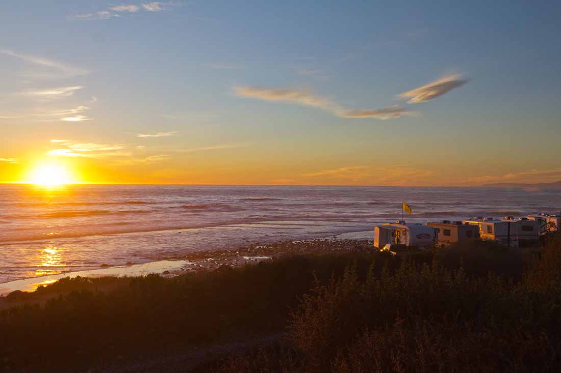 RV campers parked along the beach at sunset in southern California