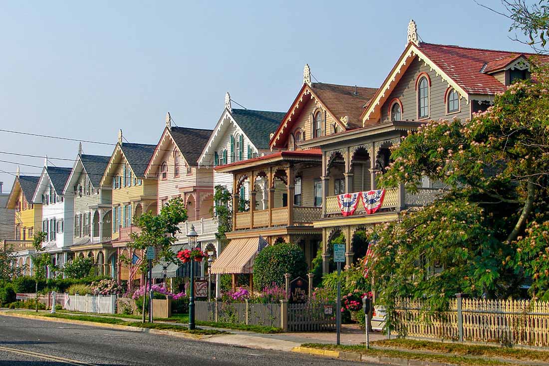 Flag-draped Victorian houses line a residential street.