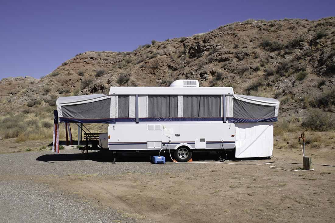 A small camper trailer is parked at a desert campsite in Bottomless Lakes State Park near Roswell, New Mexico.