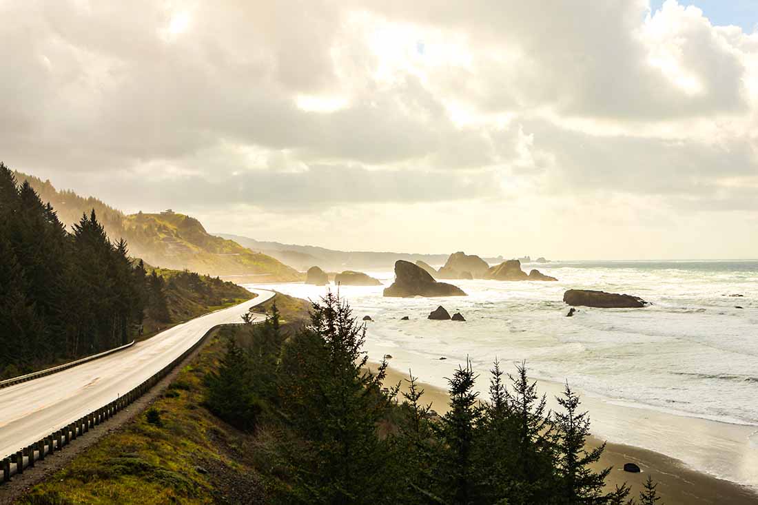 the sun breaks through the clouds on a rainy day on the Oregon Coast.