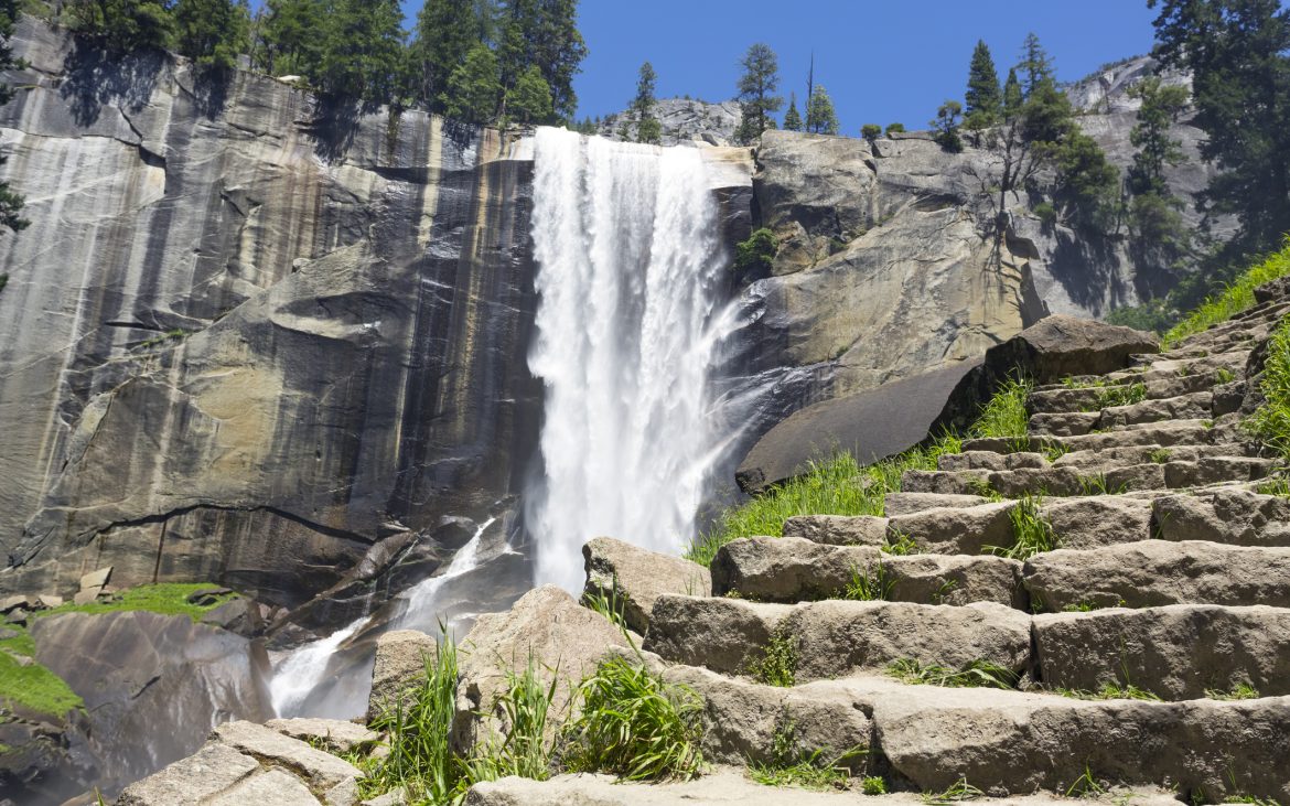 Massive waterfall with rock stairs leading up in Yosemite