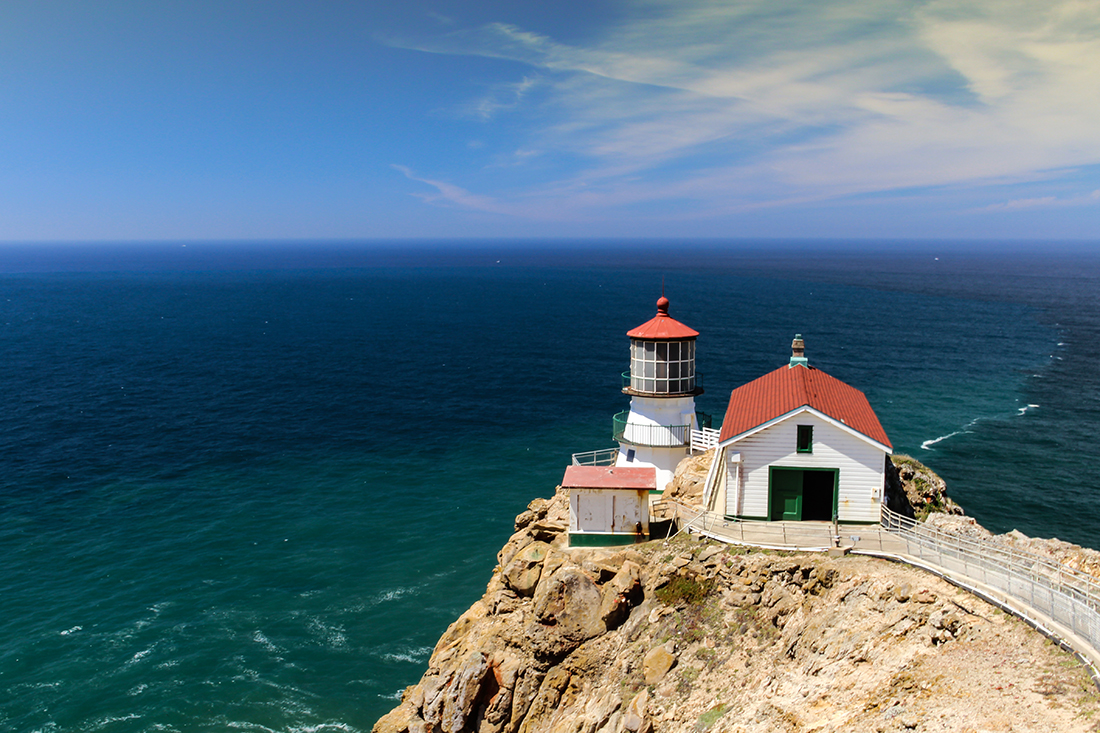 A lighthouse perched on the edge of a coast.