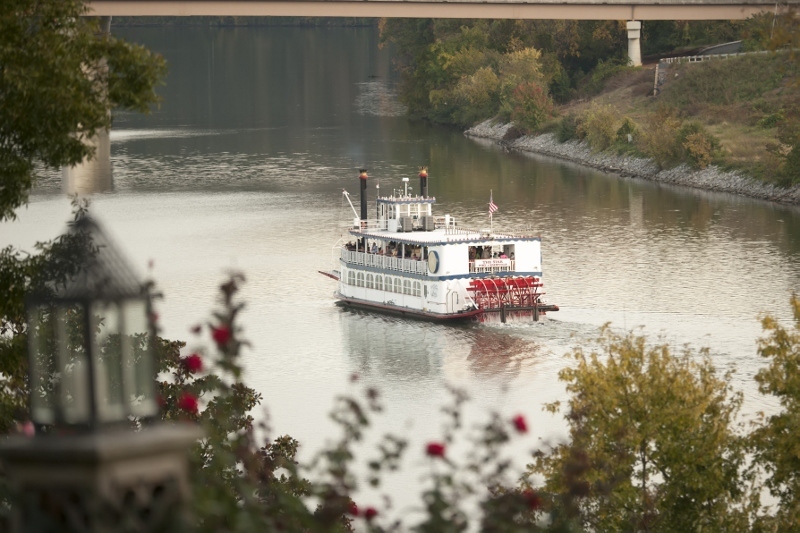 Tennessee Paddleboat A paddleboat chugs off into the distance down a river.