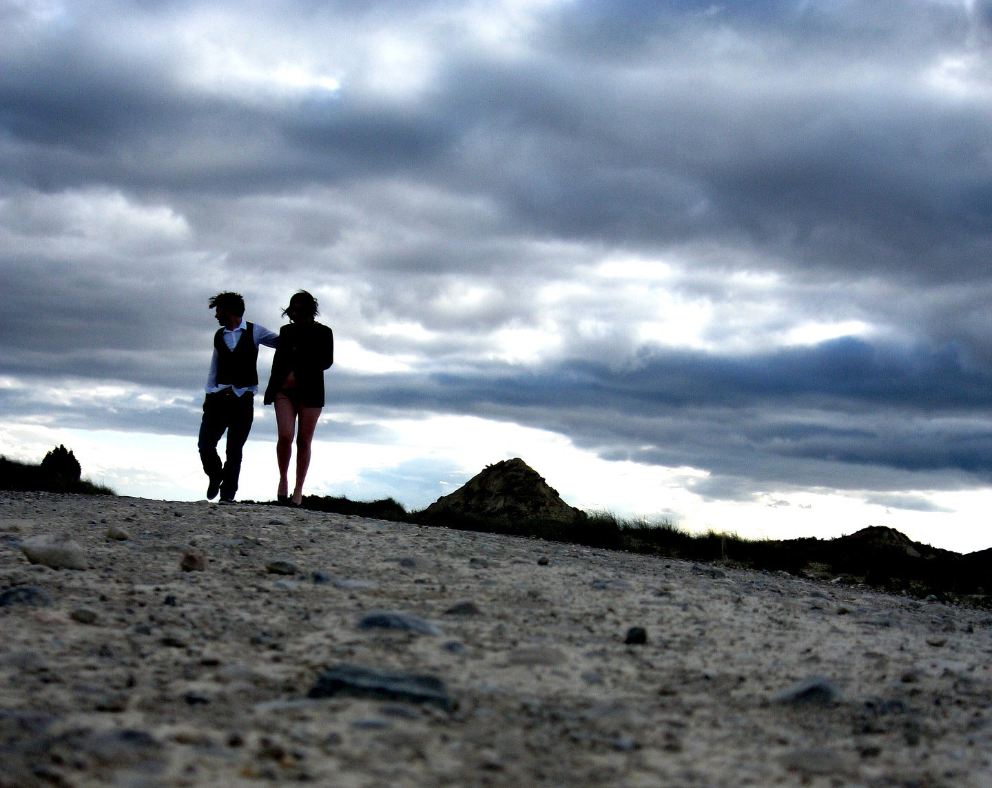 Couple in Tucson A couple walk across a barren desert landscape.