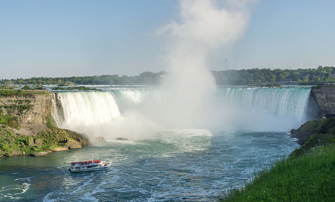 A boat churns close to the foot of Niagara Falls.