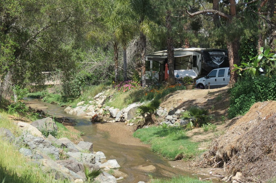 An RV campsite near a creek bed