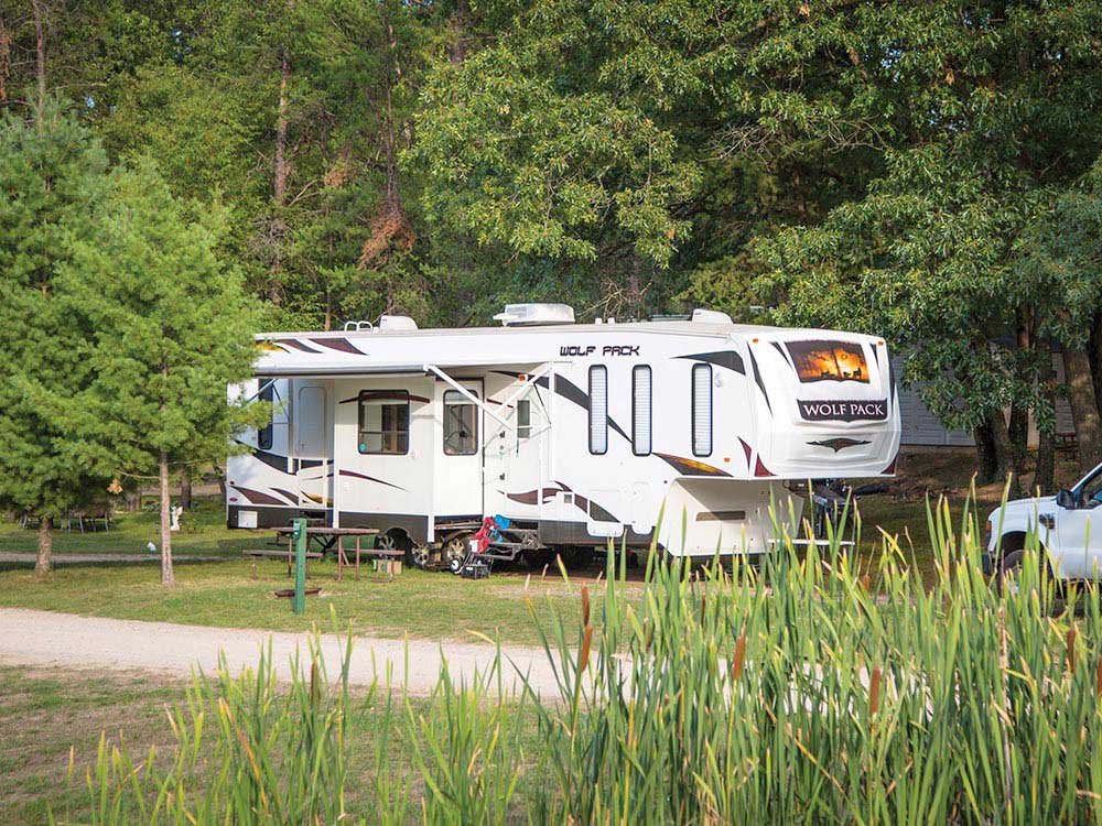 A fifth-wheel trailer parked in an ample site.