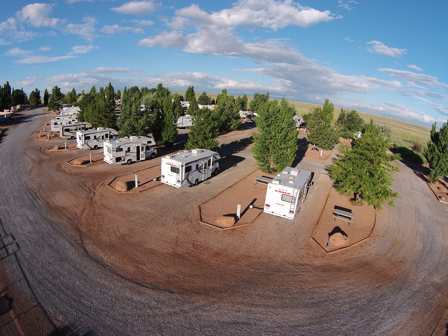 Aerial view of desert RV park with trees.