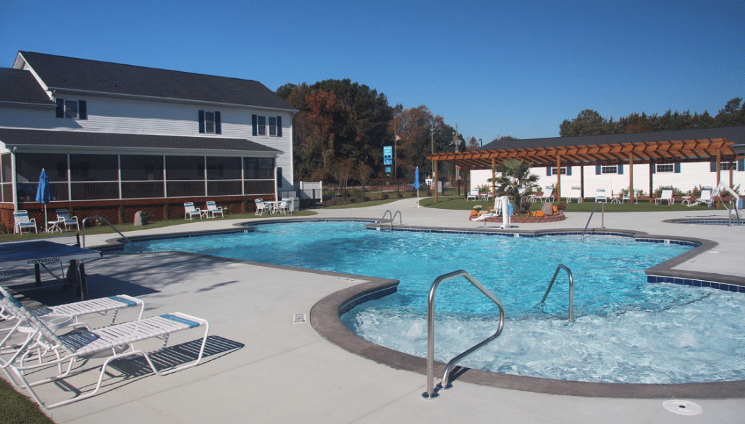 A pool with clubhouse in background.