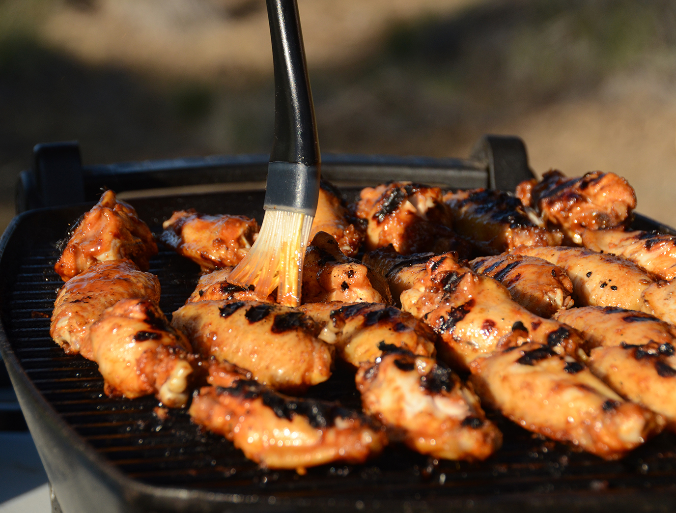 Basting brush on chicken on the grill