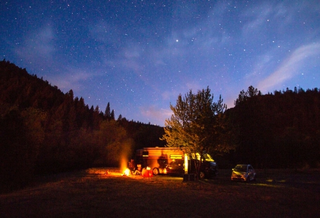 A campfire outside of an RV