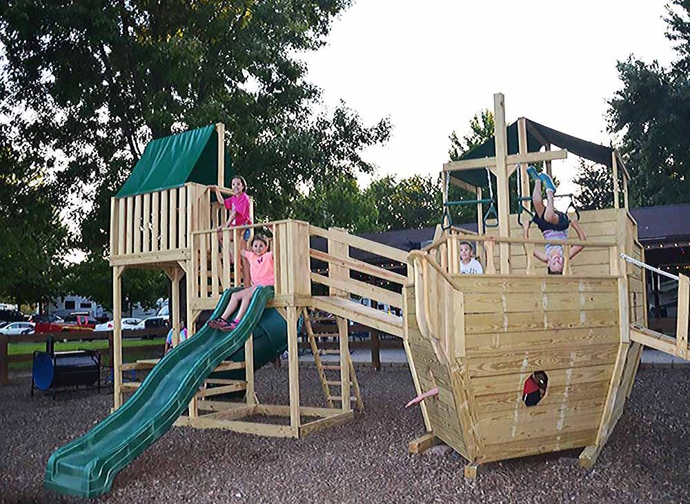 an award-winning campground — Kids play on a boat in a playground.