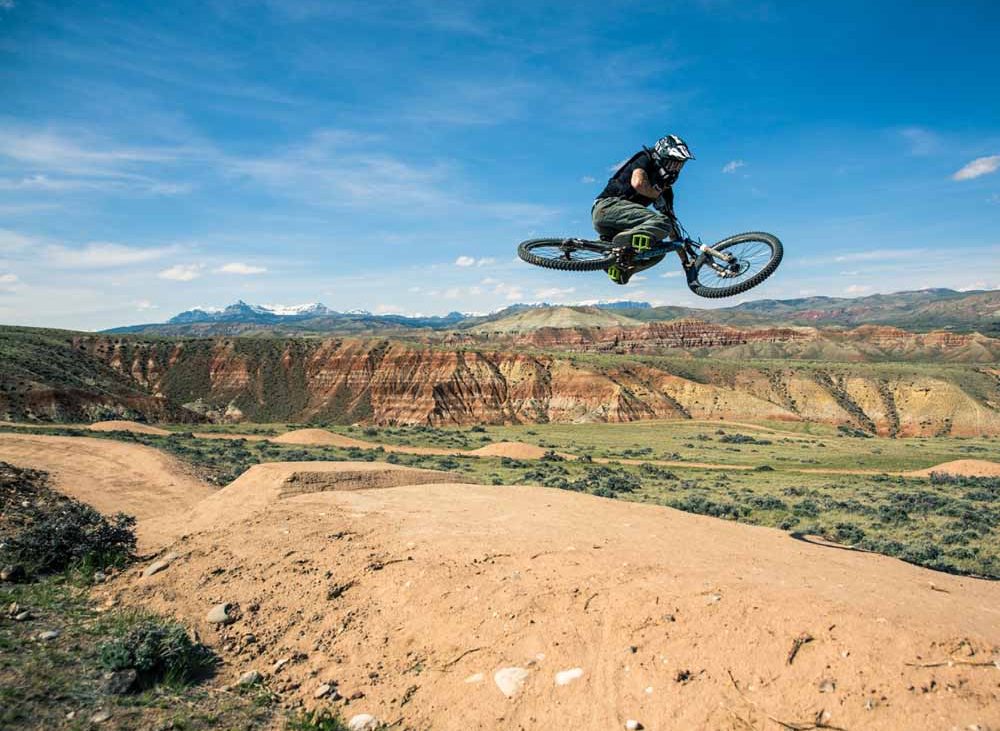 A cyclist gets some air on badlands.