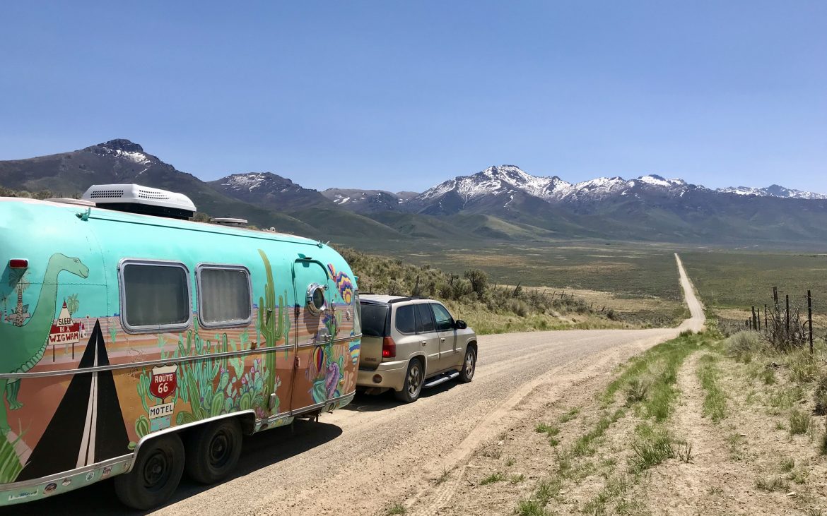 SUV pulling colorful Airstream trailer on Northeastern Nevada dirt road