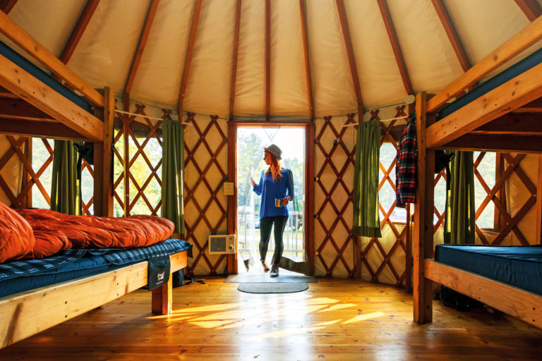 A camper enters a yurt